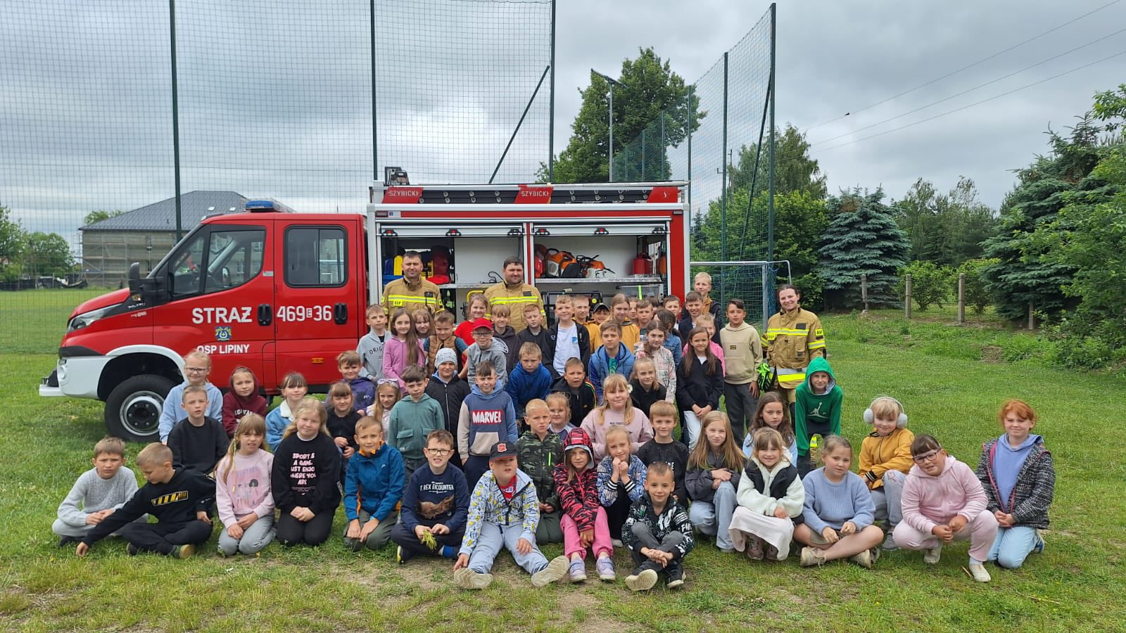Zdjęcie grupowe uczniów i strażaków na tle wozu strażackiego